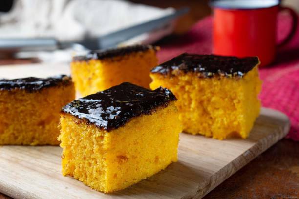 slices of carrot cake, over wooden surface with coffee cup in the background